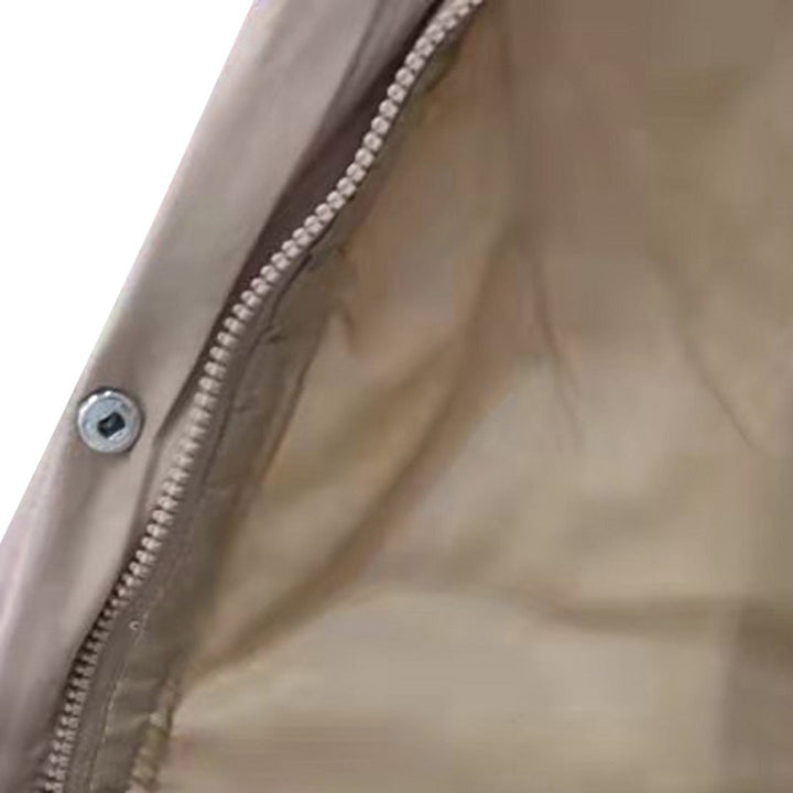 Beige jas met metalen knoop en ritssluiting, close-up van binnenvoering. Modieuze dameskleding, hoogwaardige materialen, stijlvolle jas.