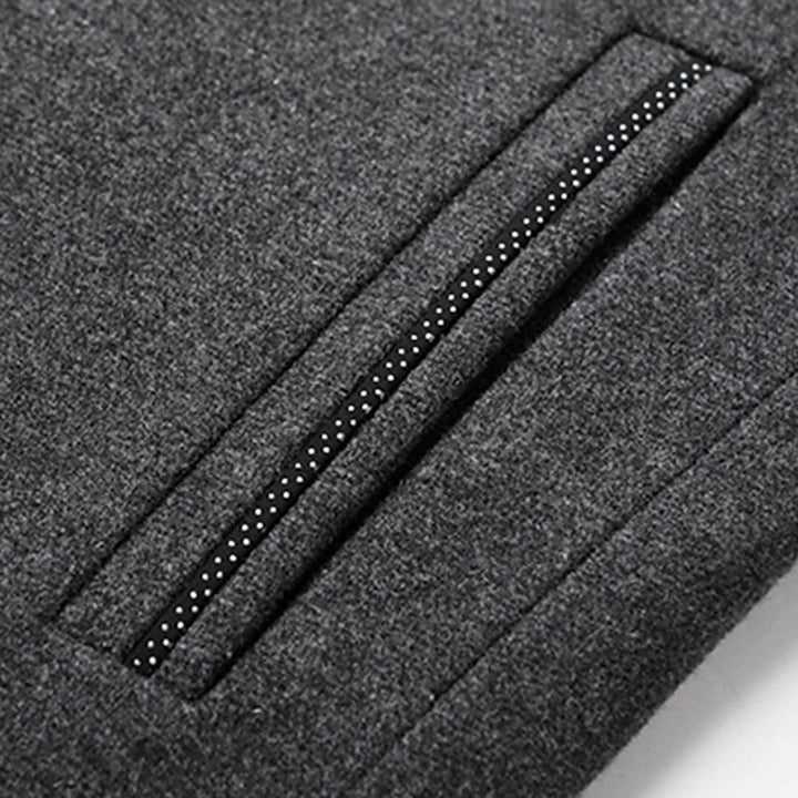Grijze wollen jas met gestreepte zak, stijlvolle wintermode, hoogwaardige stof, close-up detail, moderne herenkleding.