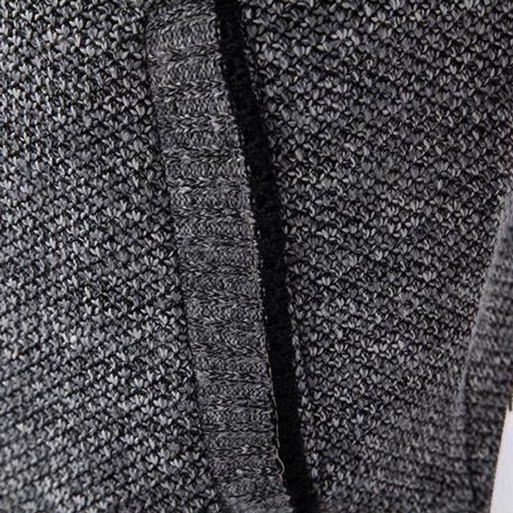 Grijze gebreide trui close-up, textuur en patroon zichtbaar. Hoogwaardige wol, comfortabele wintermode, stijlvolle herenkleding.