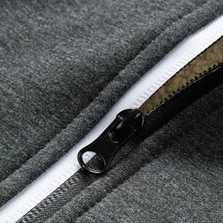 Grijze ritssluiting op fleecejack, close-up. Hoogwaardige metalen rits, duurzaam en stijlvol. Perfect voor outdoor kleding en sportmode.