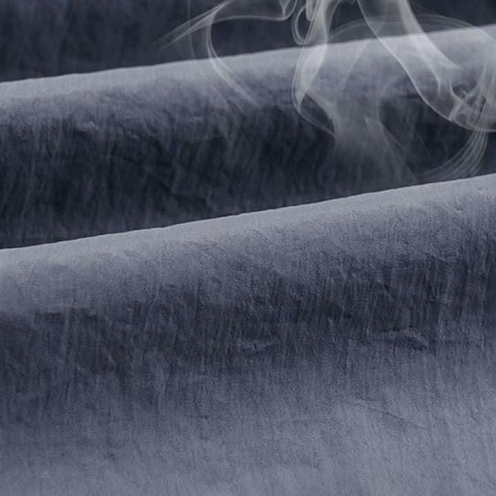 Donkergrijze, kreukvrije stof met stoomwolken, ideaal voor strijkvrije kleding en interieurtextiel. Hoogwaardige textielkwaliteit.