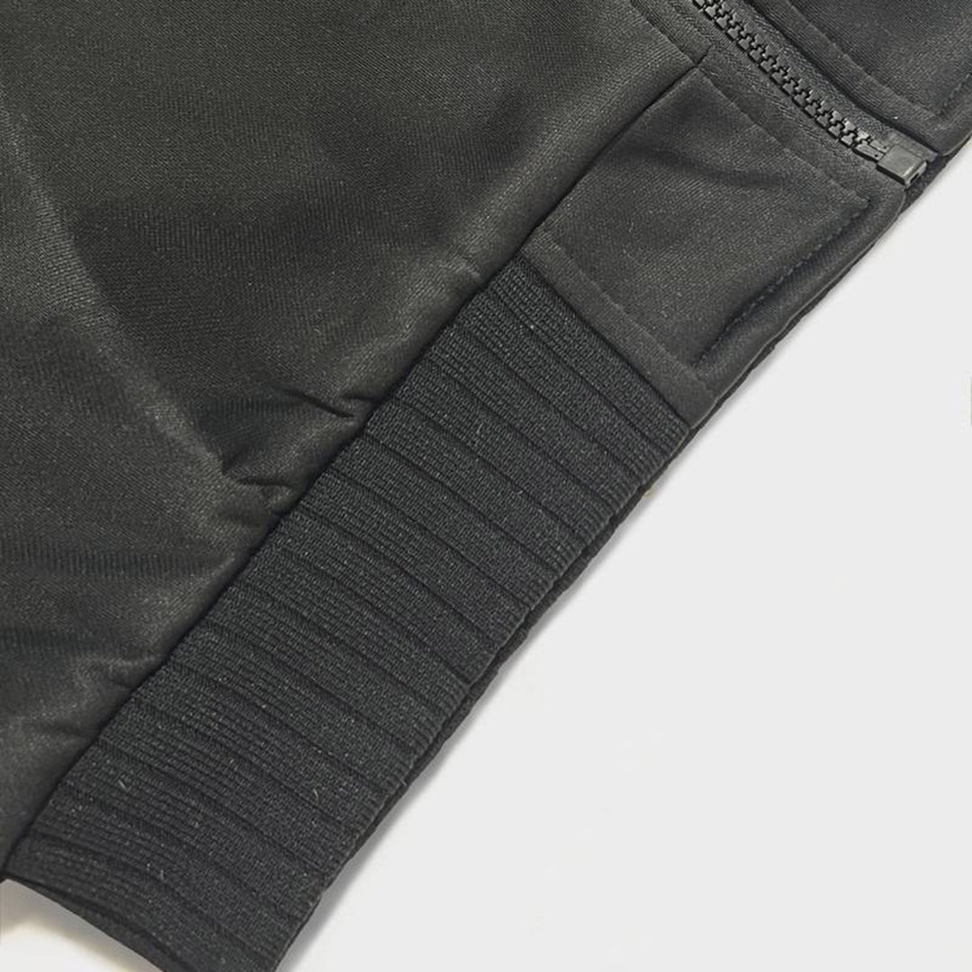 Zwarte sportbroek met elastische tailleband en ritssluiting, close-up. Hoogwaardige fitnesskleding, comfortabel en duurzaam materiaal.