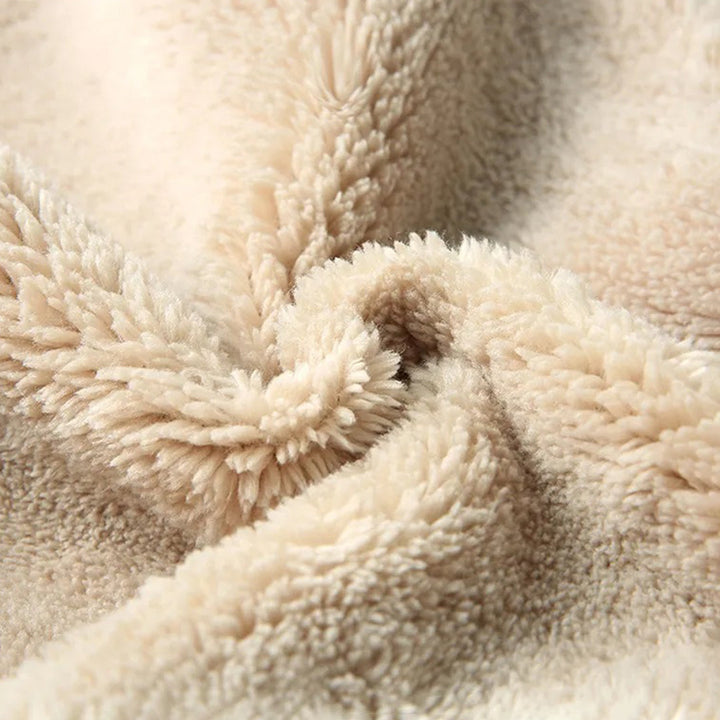 Zachte beige fleece stof close-up, pluche textuur, ideaal voor warme dekens en kleding. Perfect voor wintercomfort en huisdecoratie.