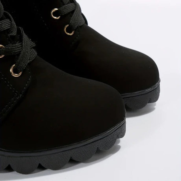 Zwarte leren laarzen met veters en stevige rubberen zool, close-up. Modieuze dameslaarzen, ideaal voor herfst en winter. Comfortabel en stijlvol.