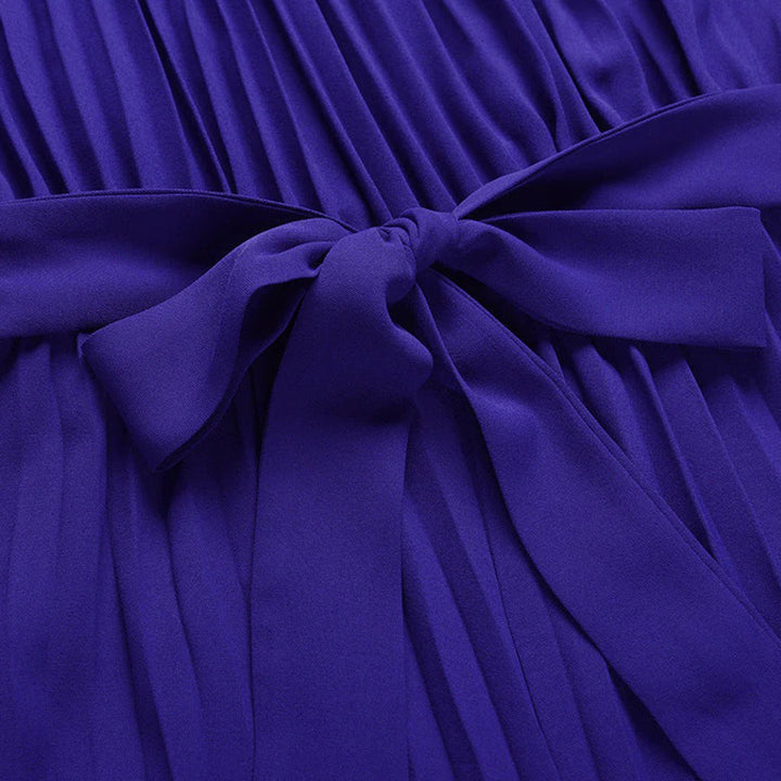 Paarse geplooide jurk met strikdetail, elegante damesmode, stijlvolle avondkleding, hoogwaardige stof, trendy design, perfect voor speciale gelegenheden.