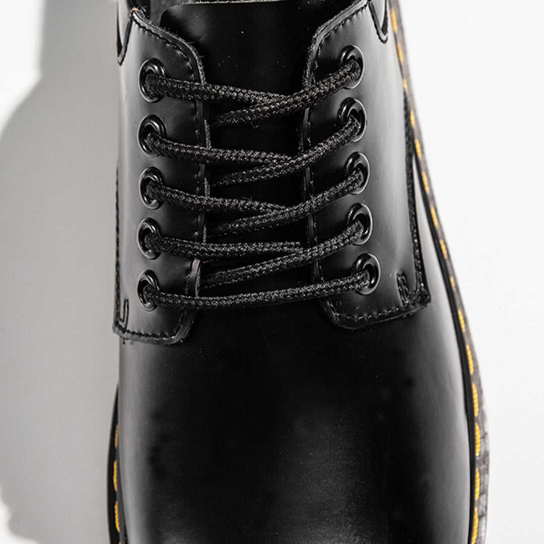 Zwarte leren veterlaars met gele stiksels, close-up. Stijlvolle en duurzame schoenen, perfect voor casual en formele gelegenheden.