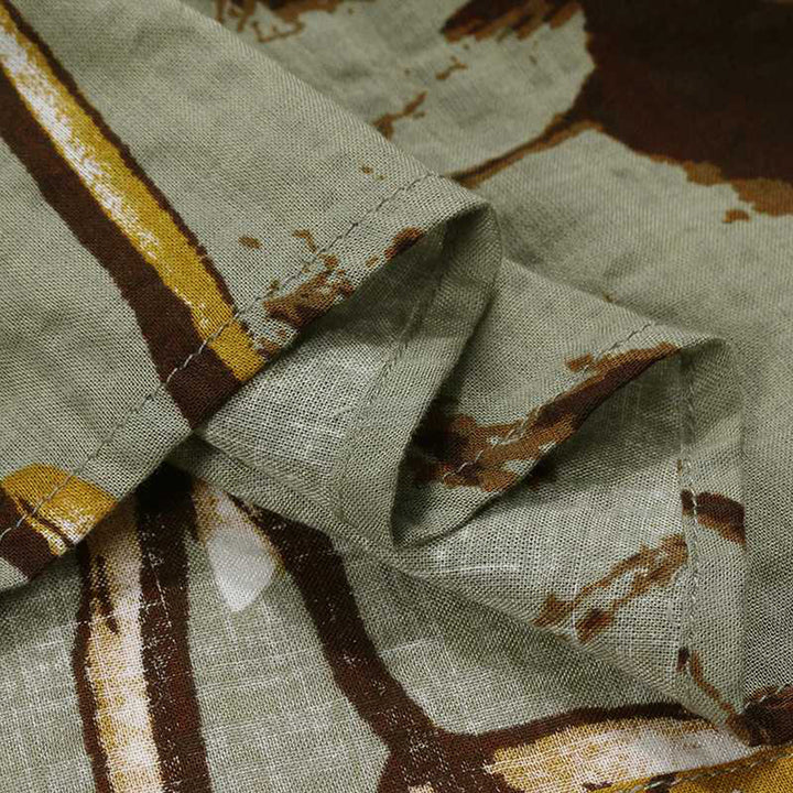 Groene linnen stof met abstract bruin en geel patroon, close-up. Hoogwaardige textieltextuur, geschikt voor mode en interieurontwerp.