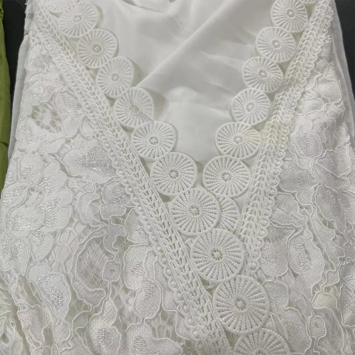 Witte kanten stof met bloemmotief en cirkelvormige borduursels, geschikt voor bruidsjurken en elegante kleding. Hoogwaardige kantstof voor modeontwerp.