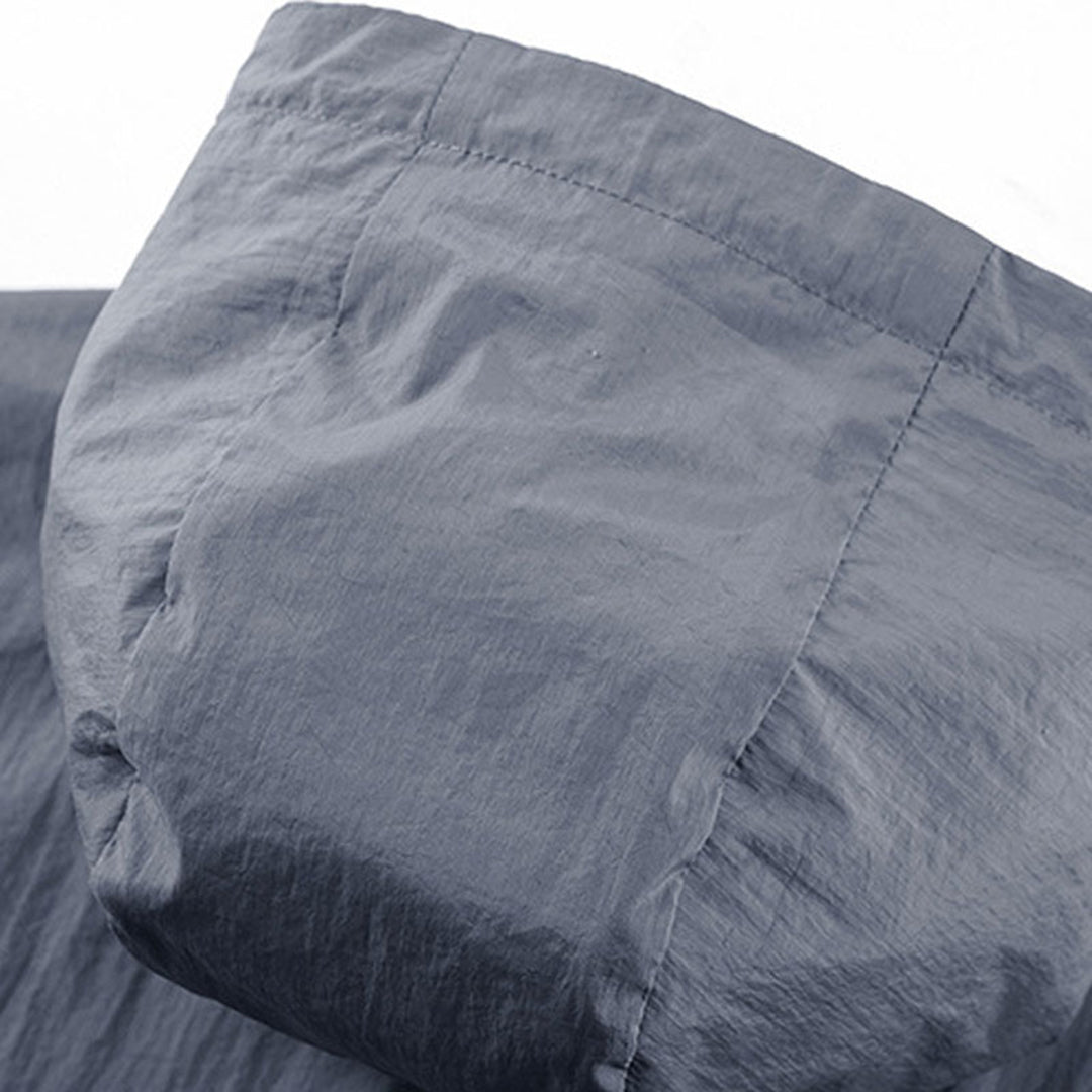 Grijze gewatteerde jas met capuchon, close-up van de stoftextuur. Hoogwaardige winterkleding, duurzaam en stijlvol ontwerp.