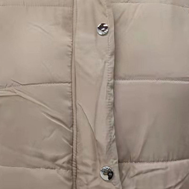 Beige gewatteerde jas met zilveren drukknopen, close-up. Modieuze winterjas, warme isolatie, trendy design, ideaal voor koude seizoenen.