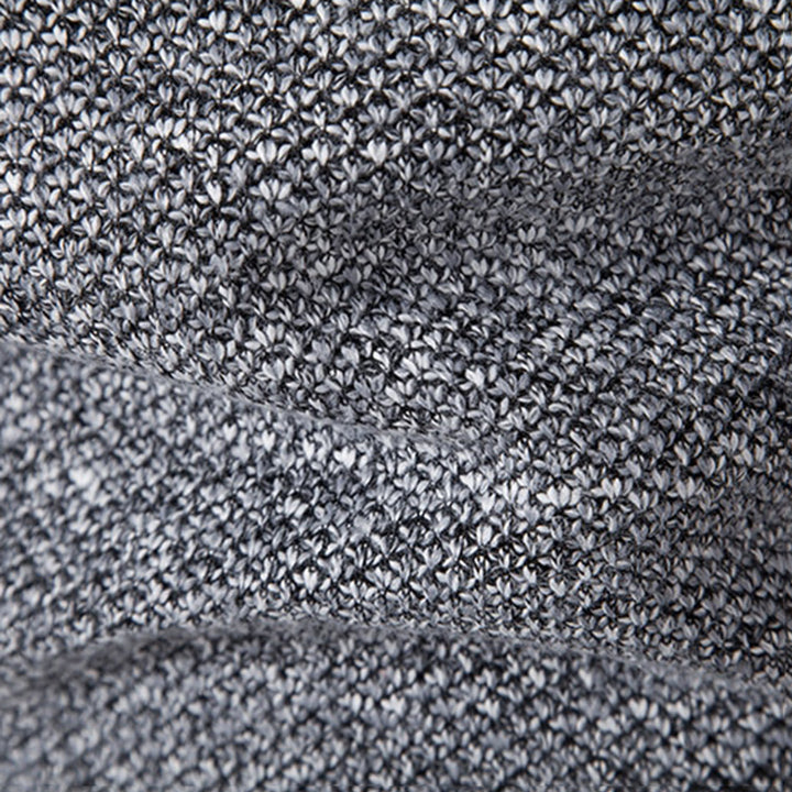 Grijze gebreide stof close-up, textuur met fijne steken, ideaal voor mode, interieur en ambachtelijke projecten. Hoogwaardige textielmaterialen.