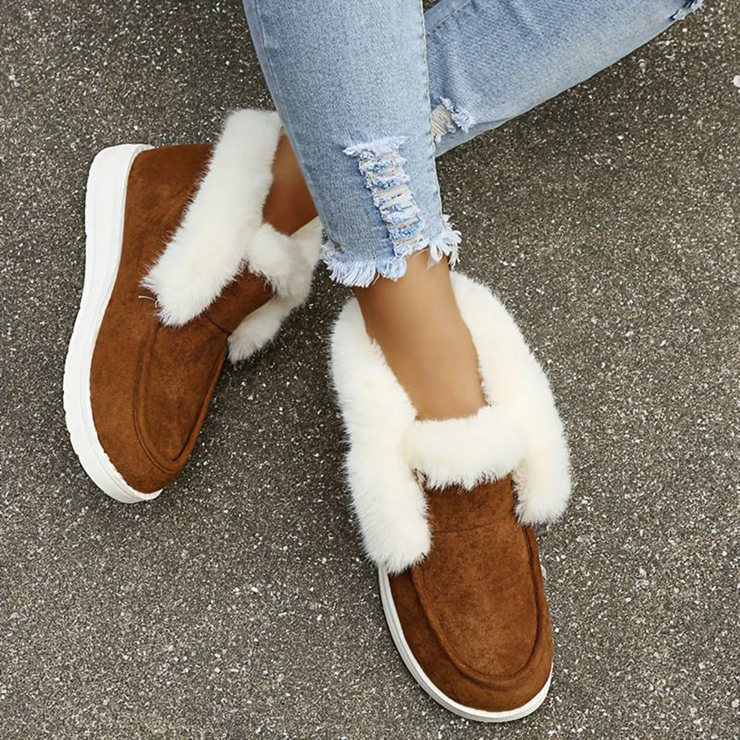 Bruine suède laarzen met witte bontvoering, gedragen met gescheurde spijkerbroek. Comfortabele wintermode, trendy dames schoenen.
