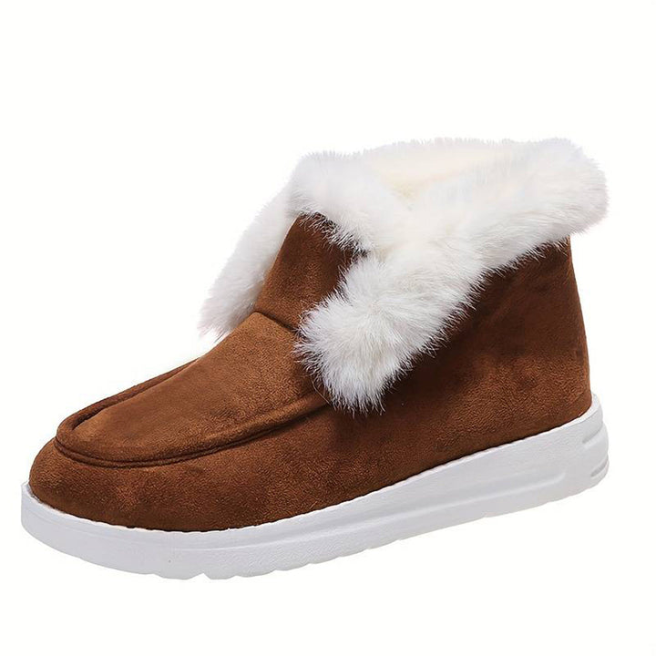 Bruine suède winterlaars met witte bontkraag en dikke witte zool, ideaal voor koude seizoenen. Comfortabele en warme dameslaars.
