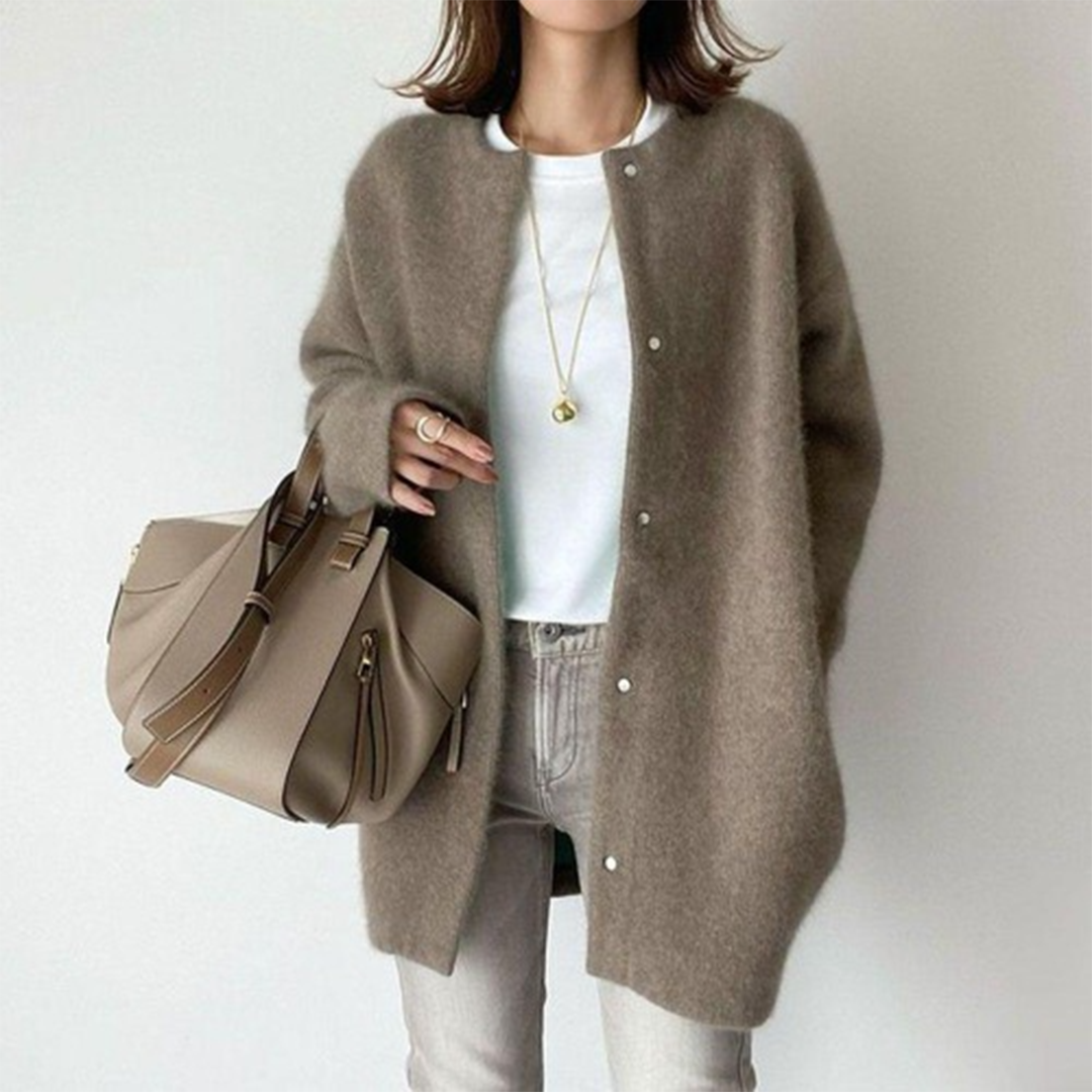 Vrouw in stijlvolle bruine wollen jas met witte top en beige handtas. Modieuze herfstoutfit, casual chic, damesmode.