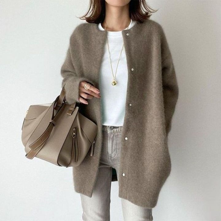 Vrouw in stijlvolle bruine wollen jas met witte top en beige handtas. Modieuze herfstoutfit, casual chic, damesmode.
