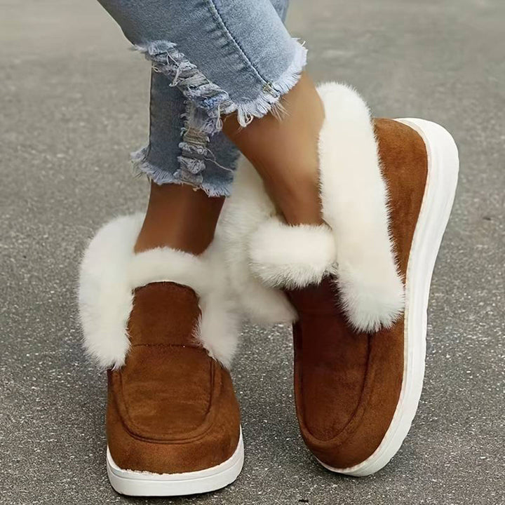 Bruine suède damesschoenen met witte bontvoering, gedragen met gescheurde jeans. Comfortabele wintermode, warme schoenen, casual stijl.