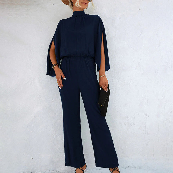 Donkerblauwe dames jumpsuit met wijde pijpen en kapmouwen, elegante avondkleding, modieuze outfit voor speciale gelegenheden.