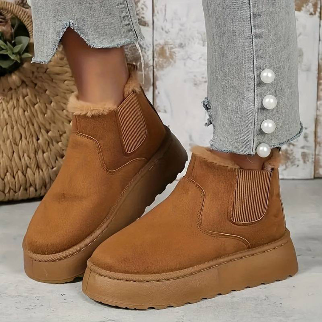 Bruine suède enkellaarsjes met bontvoering, elastische inzetstukken en dikke zool. Modieuze dameslaarzen, perfect voor herfst- en winteroutfits.