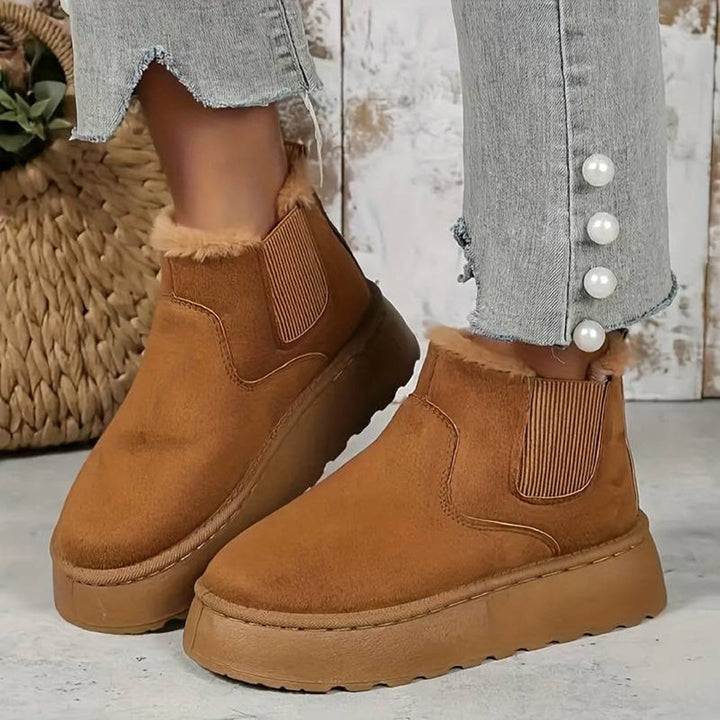 Bruine suède enkellaarsjes met bontvoering, elastische inzetstukken en dikke zool. Modieuze dameslaarzen, perfect voor herfst- en winteroutfits.