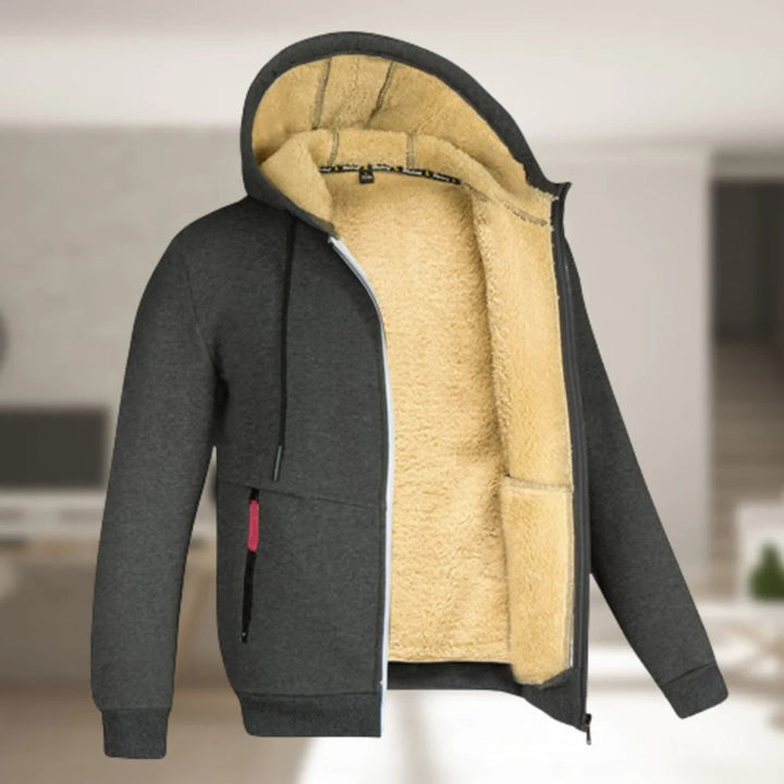 Donkergrijze hoodie met beige fleecevoering, ritssluiting en capuchon. Comfortabele winterkleding, ideaal voor casual en warme outfits.