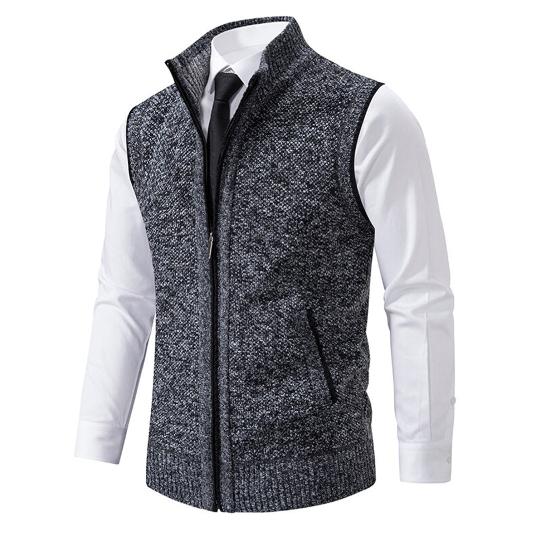 Donkergrijs herenvest met ritssluiting, gedragen over een witte overhemd en zwarte stropdas. Stijlvolle, casual herenkleding.