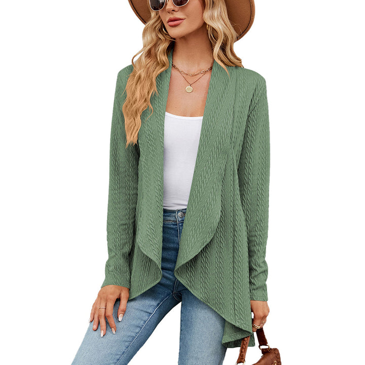 Vrouw draagt groene kabelgebreide cardigan, witte top, jeans en hoed. Modieuze dameskleding, herfstoutfit, casual stijl.
