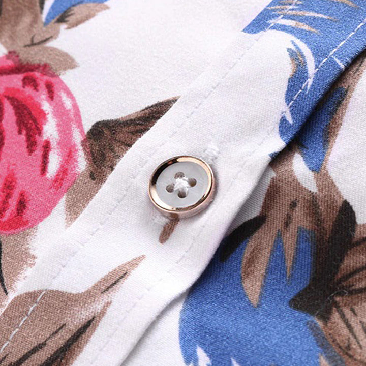 Close-up van een kleurrijk bloemenhemd voor mannen met knoopdetail, roze en blauwe bloemenprint op witte stof. Perfect voor zomermode en casual stijl.
