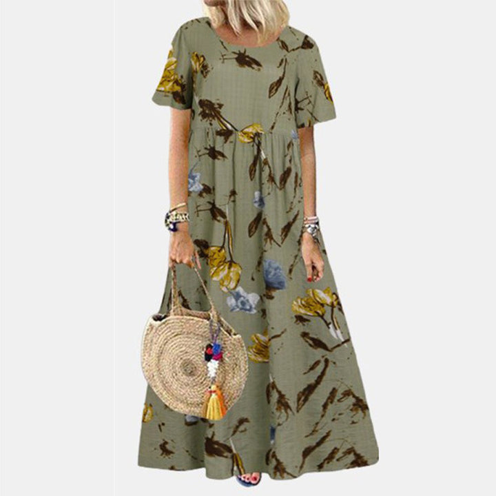 Vrouw in groene maxi-jurk met bloemenprint, draagt een ronde rieten tas. Zomerse damesmode, casual boho-stijl, comfortabele kleding.