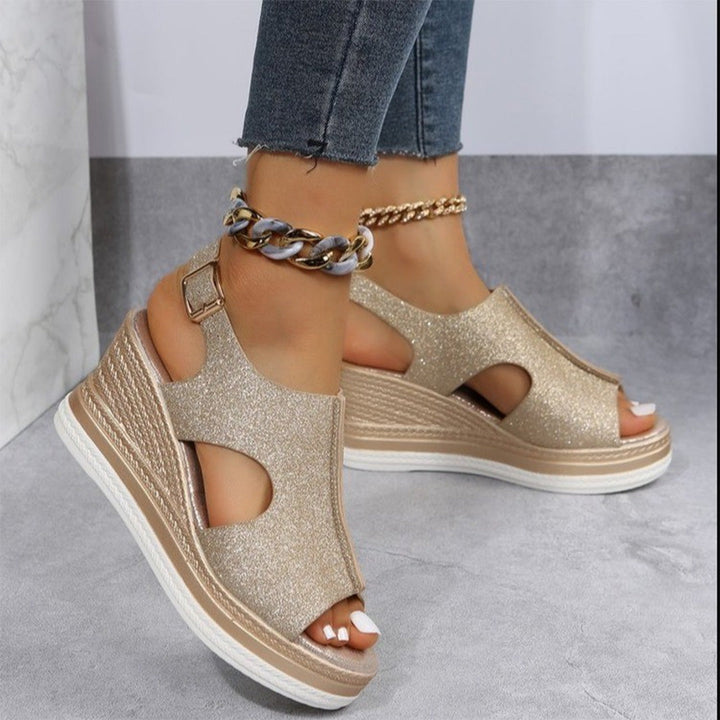 Gouden glittersandalen met sleehak, open teen en enkelband, gedragen met jeans. Trendy damesmode, comfortabele zomerschoenen.