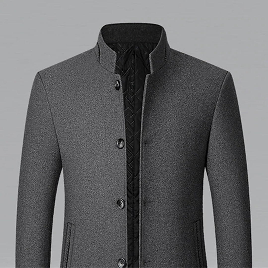 Grijze herenjas met opstaande kraag, knoopsluiting en steekzakken. Stijlvolle winterjas, ideaal voor formele en casual gelegenheden.