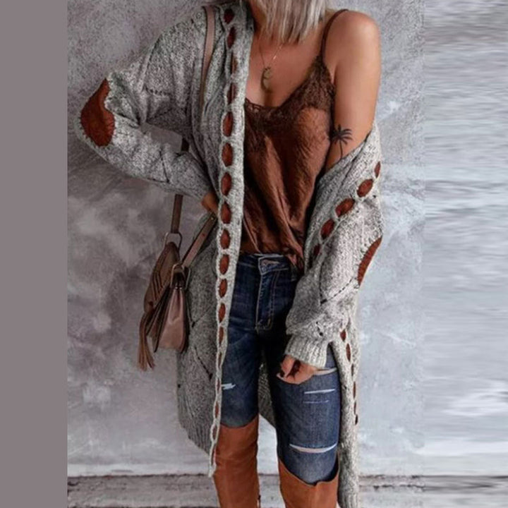Grijze gebreide damesvest met bruine details, gecombineerd met een bruine top, jeans en hoge laarzen. Modieuze herfstoutfit voor casual stijl.