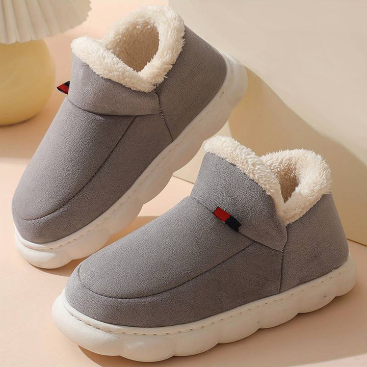 Grijze pluche pantoffels met witte zool, warme voering en modern design. Perfect voor comfort en stijl in huis. Unisex winter sloffen.