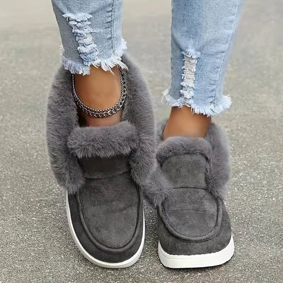 Grijze suède damesschoenen met bontvoering, gedragen met gescheurde jeans. Comfortabele wintermode, trendy en stijlvol schoeisel.