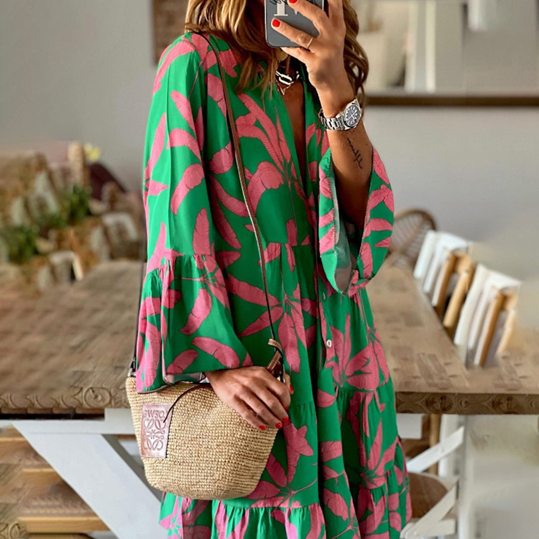 Vrouw in groene jurk met roze bladerenpatroon, houdt een rieten tas vast. Mode, zomerjurk, casual stijl, trendy accessoires.