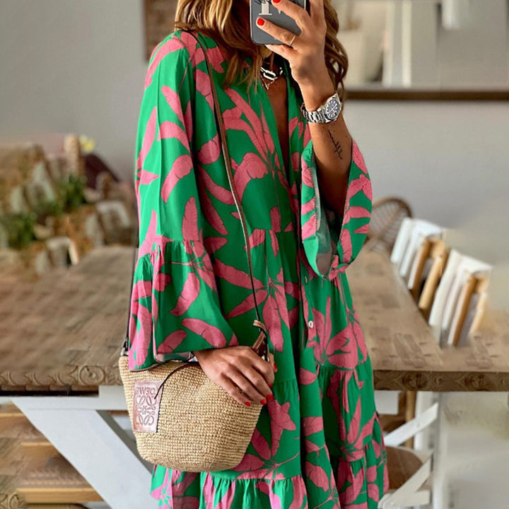 Vrouw in groene jurk met roze bladerenpatroon, houdt een rieten tas vast. Mode, zomerjurk, casual stijl, trendy accessoires.