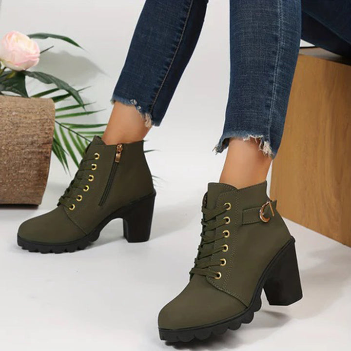 Groene dameslaarzen met hoge hak, veters en ritssluiting, gedragen met gescheurde jeans. Modieuze enkellaarzen voor dames, herfst/winter stijl.