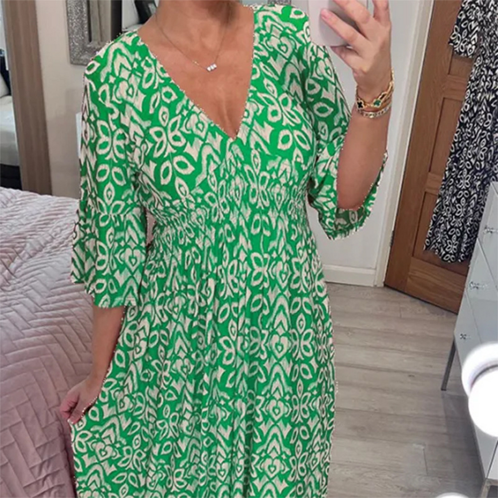 Groene boho maxi-jurk met witte bloemenprint, diepe V-hals en driekwart mouwen, perfect voor zomerse casual outfits en stranddagen.