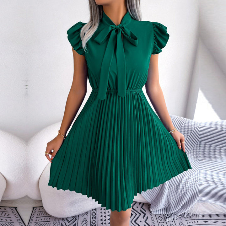 Groene geplooide jurk met strik, korte mouwen en elegante uitstraling. Perfect voor zomerfeesten en casual chique gelegenheden. Trendy damesmode.