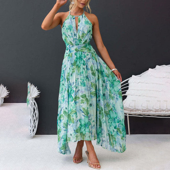 Vrouw in elegante groene bloemenjurk, halternek, asymmetrische zoom, zomermode, casual chic, perfect voor strand- of tuinfeesten.