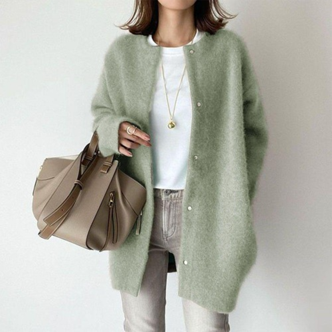 Vrouw in groene wollen cardigan, witte top en beige tas. Modieuze herfstoutfit, casual stijl, dameskleding, comfortabele look.