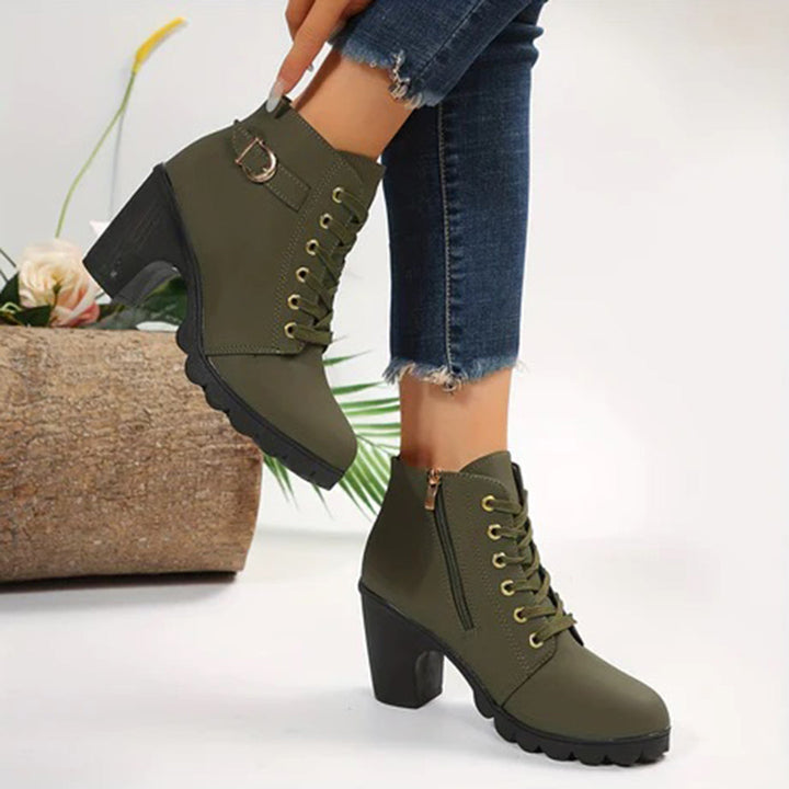 Olijfgroene dameslaarsjes met hoge hak, veters en ritssluiting, gecombineerd met jeans. Modieuze enkellaarsjes voor herfst en winter.
