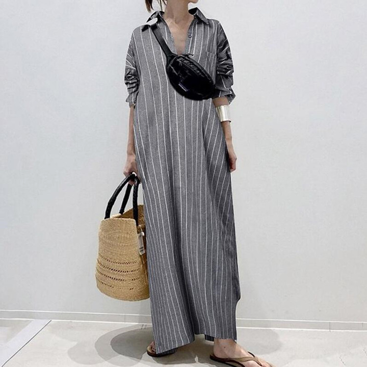 Grijze gestreepte maxi-jurk met opgerolde mouwen, gecombineerd met een zwarte heuptas en een rieten strandtas. Perfect voor zomerse casual outfits.