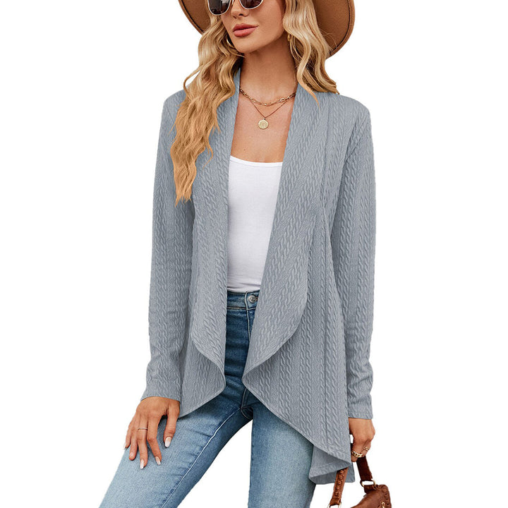 Vrouw in grijs-blauw gebreid vest, witte top, jeans en hoed. Modieuze dameskleding, casual herfstoutfit, trendy vest voor dames.
