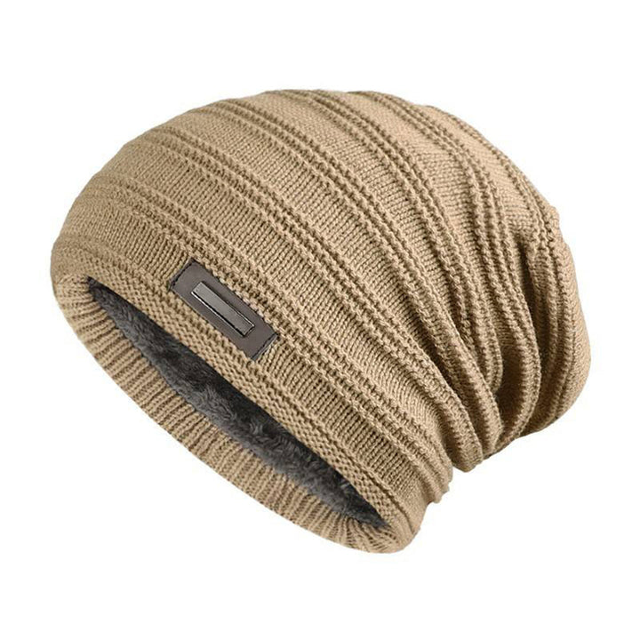Beige gebreide wintermuts met geribbelde textuur en grijze fleecevoering, ideaal voor koude dagen. Stijlvolle en warme unisex accessoire.