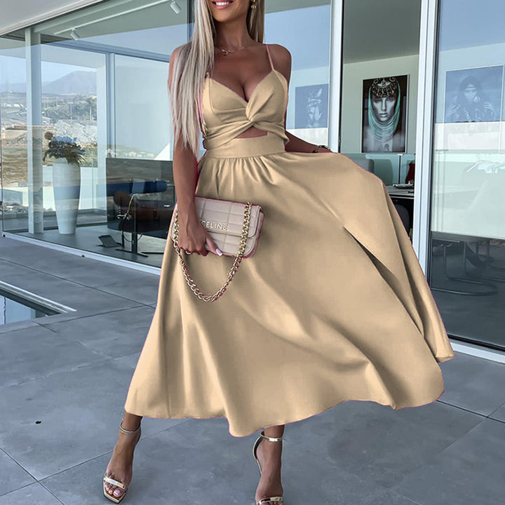Vrouw in elegante khaki jurk met diepe V-hals en split, poseert buiten bij modern huis. Perfect voor zomerfeestjes en modieuze evenementen.