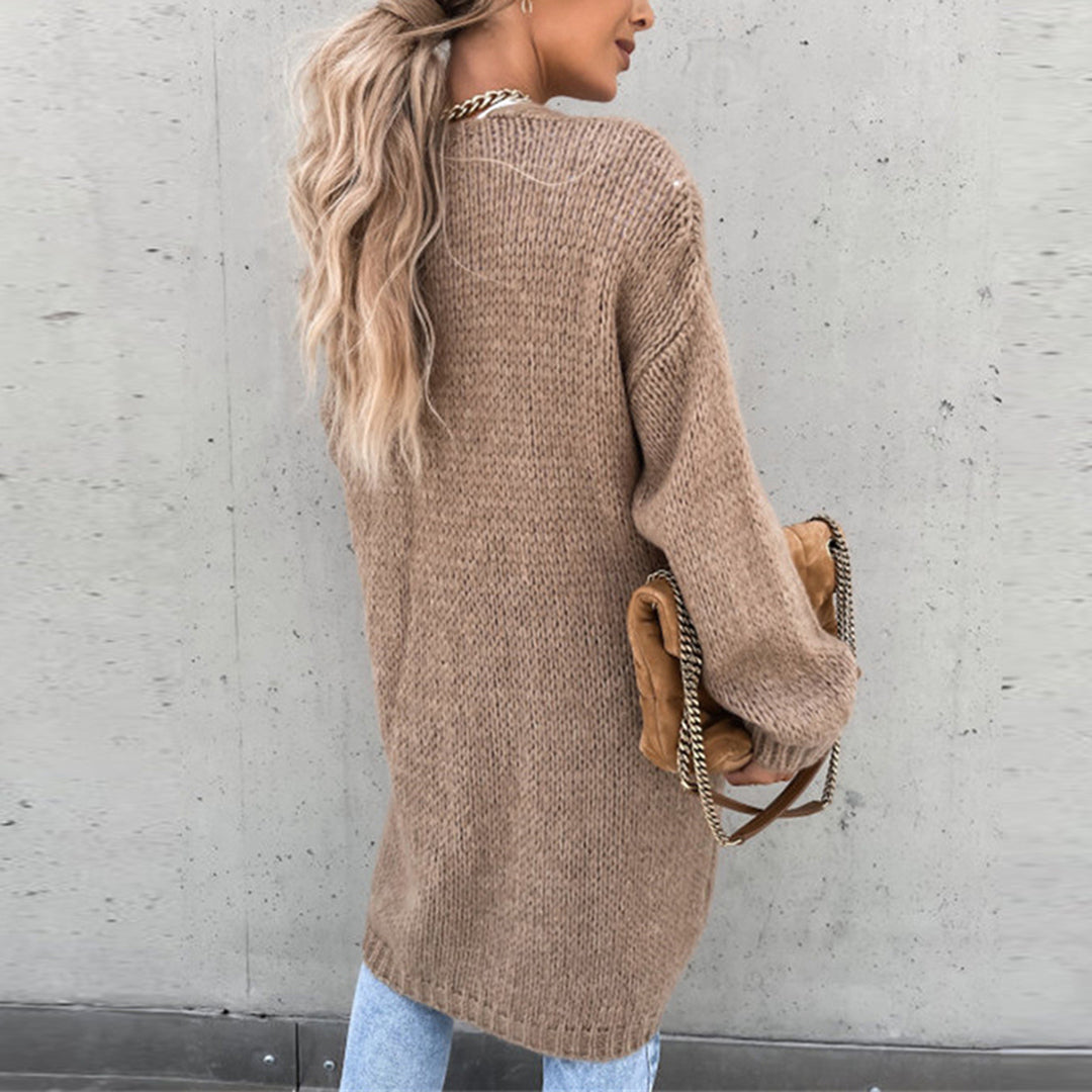 Vrouw in beige gebreide trui met lange mouwen, draagt een bruine tas met gouden ketting, casual mode, herfstkleding, trendy damesoutfit.