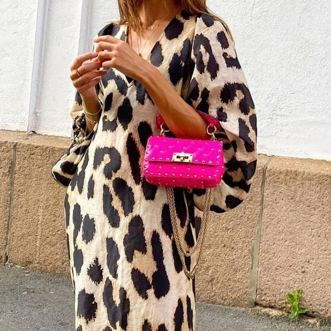 Vrouw in luipaardprint jurk met felroze handtas, straatmode, trendy outfit, casual chique stijl, modeaccessoires, stedelijke achtergrond.
