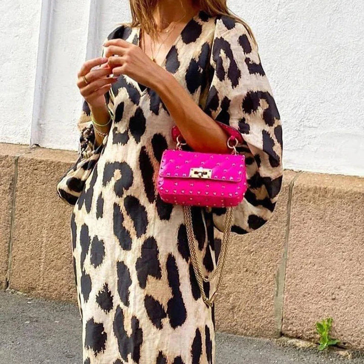 Vrouw in luipaardprint jurk met felroze handtas, straatmode, trendy outfit, casual chique stijl, modeaccessoires, stedelijke achtergrond.