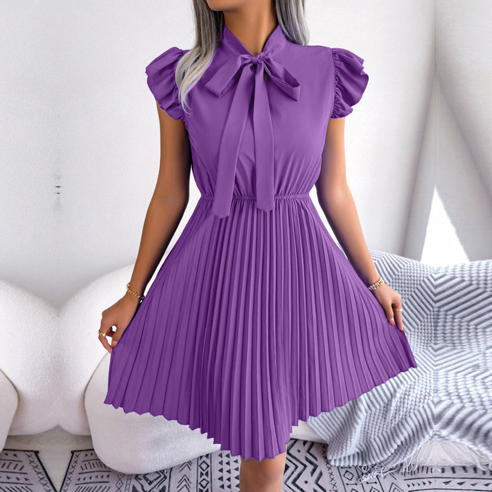 Paarse plissé jurk met strik, korte mouwen en elegante uitstraling. Perfect voor zomerfeestjes en casual chique gelegenheden. Trendy damesmode.