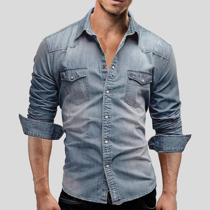 Lichtblauw denim overhemd voor heren met opgerolde mouwen, borstzakken en knoopsluiting. Casual herenmode, trendy spijkerstof.